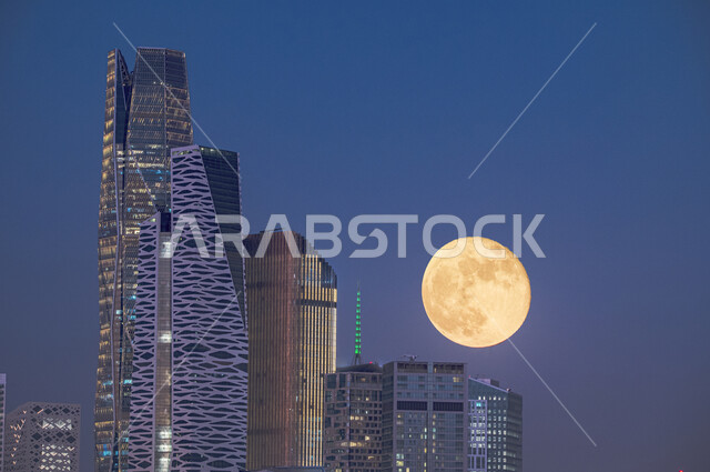 Modern architectural art, the full moon (Badr) at the top of the King Abdullah Al-Mali Towers (KAFD) in the sky of the Kingdom of Saudi Arabia, night landscapes, famous buildings and landmarks in the city of Riyadh.