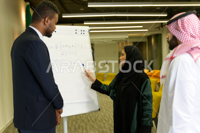 اجتماع اداري مع مجموعة من الأشخاص السعوديين مكون من سيدة اعمال  و رجال اعمال  داخل الشركة ، تقديم الأفكار للزملاء في المكتب عل لوحة بيضاء  ،  شركة سعودية ، عمل خليجي ،  فريق العمل ، دورات تدريبية ، دورات و متدربين  ، بيئة العمل