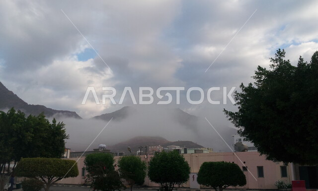 منظر السماء الملبدة بالغيوم، المباني والبيوت الأثرية القديمة، القمم والمرتفعات الجبلية، المناطق والمعالم التاريخية السياحية المشهورة في المملكة العربية السعودية، قرية رجال ألمع التراثية في منطقة عسير، الأشجار والنباتات الخضراء في القرى