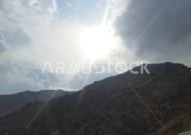 الطبيعة الصخرية لجبال السعودية, التضاريس في القمم الجبلية, السماء الملبدة بالغيوم والسحب البيضاء, التكوينات والتشكيلات الطبيعية الصخرية للمناطق المرتفعة, معالم سياحية مشهورة في مدينة الحجرة بمنطقة الباحة, السلاسل الجبلية وطرقات التنقل في المرتفعات