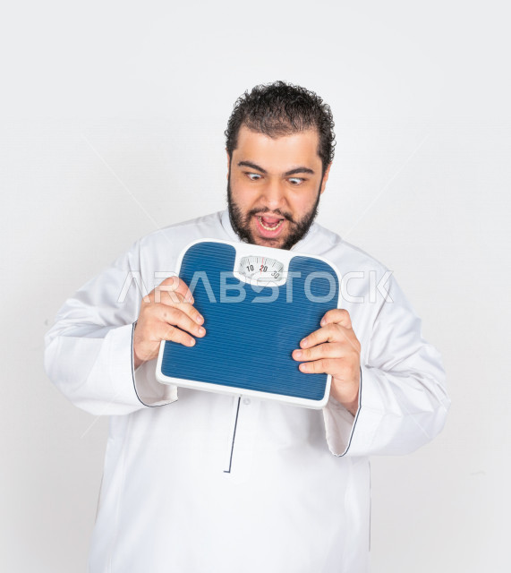 بورتريه شاب سعودي خليجي ممتلئ الجسم ، يعاني من السمنة  ،   مع ميزان لقياس الوزن ،مشاكل صحية ،الوزن الزائد والسمنة ، تراكم السعرات الحرارية 