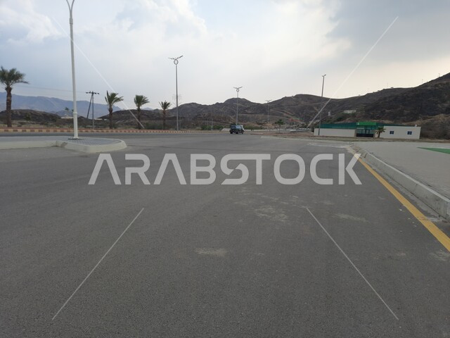 الأشجار والنباتات الخضراء المزروعة في طرقات المناطق المرتفعة, أعمدة الإنارة في شوارع المملكة العربية السعودية, المنتزهات والحدائق في مدينه الحجره بمنطقه الباحه, التضاريس والقمم والمرتفعات الجبلية في المناطق السياحية, السماء الملبدة بالغيوم والسحب البيضاء