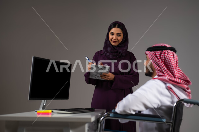 تدوين الملاحظات لتطوير خطط الشركة، دمج العمل مع التقنية والتكنولوجيا، اتاحة الفرصة امام ذوي الهمم بالدخول الى مجال العمل، بورتريه مقرب لزميلين عربيين خليجيين سعوديين مبتسمين يقومان بإنجاز المهام عبر الحاسوب المحمول داخل المكتب، روح الفريق الواحد، خلفيه رمادية