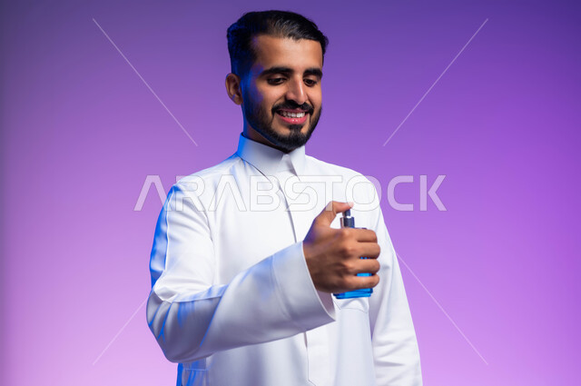 عطورات خليجية سعودية, التسويق لمنتجات العطور, مفهوم التعطر والتطيب, استخدام الزيوت العطرية الطبيعية, بورتريه مقرب لرجل عربي خليجي سعودي يرتدي الثوب التقليدي يقوم برش العطر, خلفية ملونة