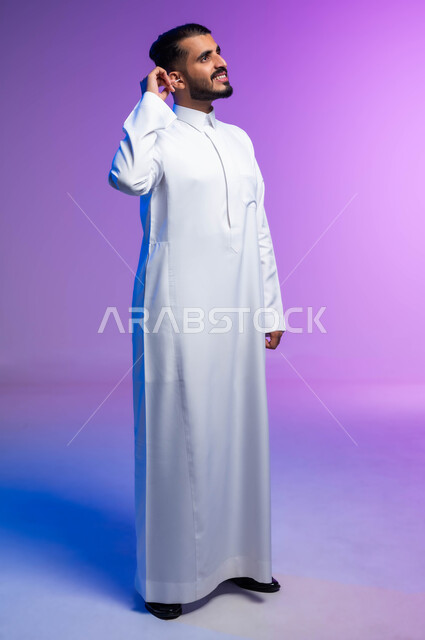 استخدام أعواد ونكاشات القطن، روتين نظافة الأذنين اليومية، بورتريه لرجل عربي خليجي سعودي يقوم بتنظيف أذنه بنكاشة قطنية ( مسحة قطنيه )، مفهوم العناية والاهتمام بصحة ونظافة الأذن، صورة الجسم بالكامل، خلفية ملونة