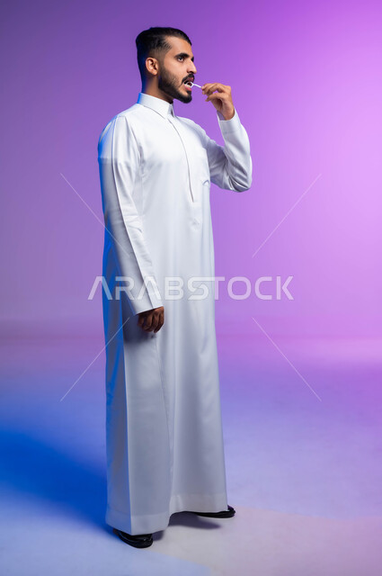 التأكد من نظافة الأسنان بعد تناول الطعام، الاهتمام بالأناقة والمظهر الخارجي، المحافظة على ابتسامة بيضاء، بورتريه من الجانب لرجل عربي خليجي سعودي يقوم بتنظيف أسنانه باستخدام الخيط السني، مفهوم العناية بصحة الفم، صورة الجسم بالكامل، خلفية ملونة
