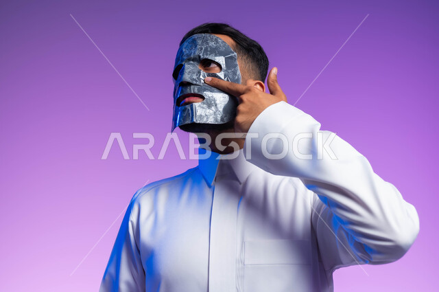 خطوات تنظيف وتقشير البشرة، بورتريه مقرب لرجل عربي خليجي سعودي يقوم بوضع قناع الطين على وجهه، مفهوم العناية والاهتمام بالمظهر الخارجي، استخدام مكونات تجميلية، خلفية بيضاء.