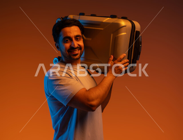 Going on recreational tourist tours during the summer vacation, looking at the camera with gestures and expressions of pleasure and happiness, a close-up portrait of a young Saudi Arabian Gulf man wearing a casual outfit carrying a travel bag on his shoulder, preparing for an enjoyable summer trip, colorful background