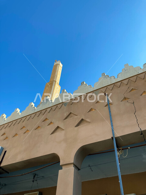 The old historical style of building mosques in Saudi Arabia, the architectural art of the Al-Jarda Mosque building in Buraydah Al-Qassim, famous Islamic religious landmarks, the view of the clear blue sky during the day
