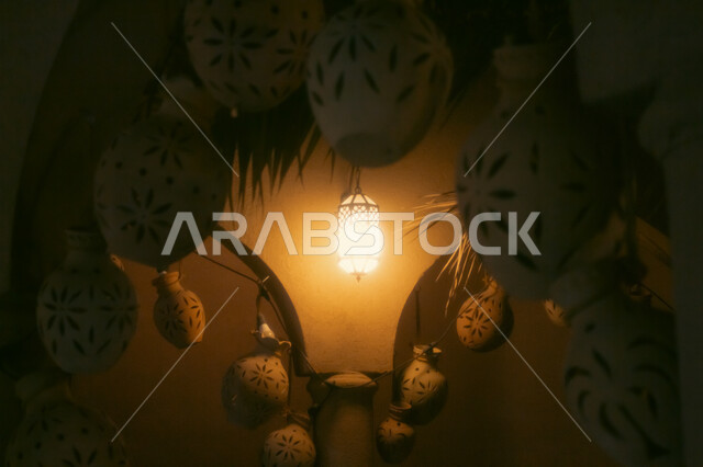 زينة وديكورات شهر الخير والبركة، فانوس معدني عربي معلق مضيئ، جرار الفخار المعلقة على الجدران، الاستعداد لاستقبال شهر رمضان المبارك