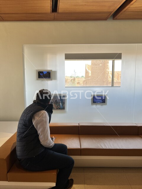 الفن الهندسي المعماري القديم لأسوار قصر سلوى في البجيري بمدينة الرياض, شاشات لعرض معالم المملكة العربية السعودية, الحضارة العربية الإسلامية القديمة, صورة من الخلف لسائح عربي من داخل إحدى المتاحف التاريخية في مطل البجيري, أماكن سياحية تراثية مشهورة