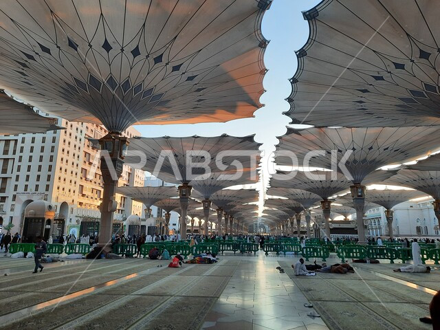 الحرم النبوي الشريف في وضح النهار، أماكن ومعالم دينية إسلامية مقدسة في المملكة العربية السعودية، تجمع المسلمون لأداء فروض الصلوات والعبادة والتقرب الى الله، المظلات الإلكترونية للتظلل والحماية، ساحة المسجد النبوي في المدينة المنورة