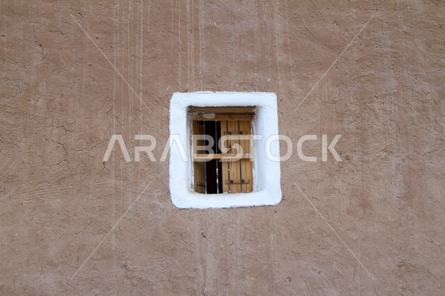 نافذة خشبية  صغيرة في الجدران الطينية على الطراز التاريخي القديم، مشاريع إعادة تأهيل القرى القديمة لجذب السياح من شتى  أنحاء العالم, القرية التراثية في مدينة المجمعة التابعة لامارة الرياض, معالم سياحية تراثية مشهورة, الحضارة والأصالة والعراقة السعودية .