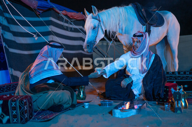   جلسات شعبية داخل خيمة تراثية، عادات وتقاليد سعودية اصيلة في تقديم القهوة العربية، شغف تربية الخيول الاصيلة، صديقان عربيان خليجيان سعوديان يرتديان الشماغ والبشت يقضيان اوقات ممتعة في كشتة بر شبابية، مفهوم كرم الضيافه وحسن الاستقبال