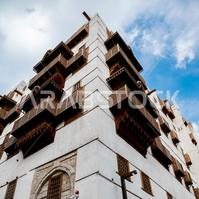 فن التصميم المعماري على الطراز العربي القديم، منظر السماء الزرقاء فوق المباني الأثرية في البلد التاريخي في جدة, المدينة التاريخية في المملكة العربية السعودية، أماكن سياحية تراثية شعبية، المعالم التاريخية في حي البلد