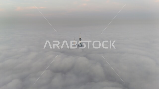 اختلاط رأس البرج مع الغيوم البيضاء القطنية، الفن الهندسي المعماري المتقدم، أماكن الجذب السياحي في مدينة الكويت،  صورة جوية علوية لأبراج الكويت الثلاثة في ساحل الخليج العربي