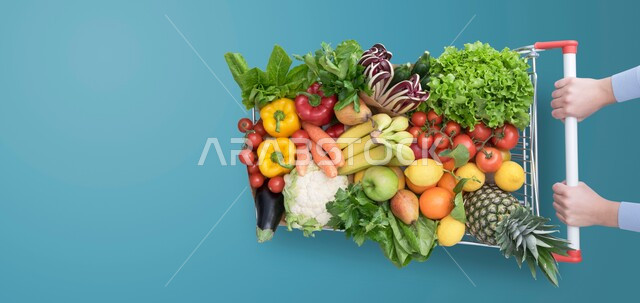 مفهوم الغذاء الصحي، صورة من الاعلى لسلة مليئة بالخضراوات والفواكه المتنوعه، التسوق وشراء الاحتياجات و المنتجات والمواد الغذائية اللازمة للمستهلك, خلفية زرقاء