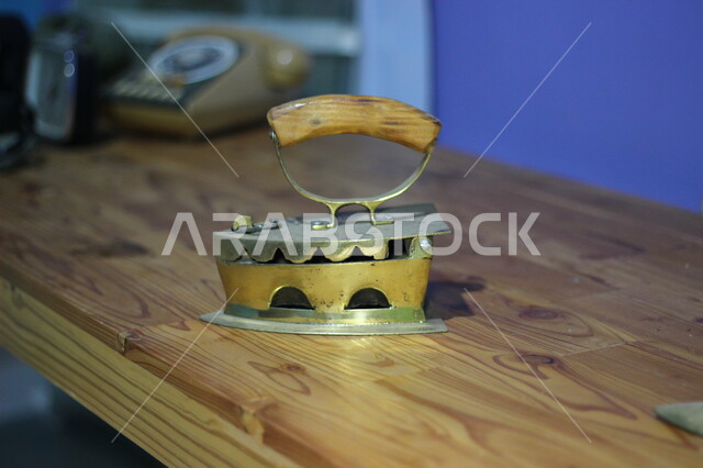 An old charcoal iron made of copper in a traditional style, popular historical tools and equipment, copper antique pieces in a museum in the Kingdom of Saudi Arabia
