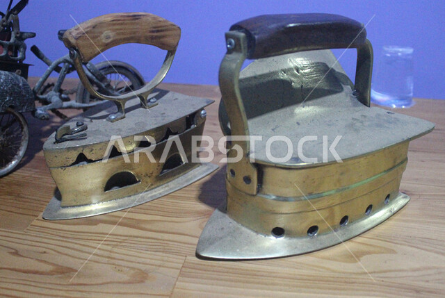 An old charcoal iron made of copper in a traditional style, popular historical tools and equipment, copper antique pieces in a museum in the Kingdom of Saudi Arabia
