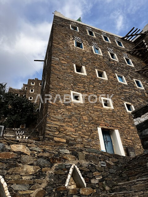 الآثار و البيوت التاريخية في أبها في المملكة العربية السعودية، رجال الفن الهندسي المعماري على الطراز القديم ،قرية رجال ألمع التراثية في منطقة عسير ،مناطق ومعالم سياحيه أثرية مشهوره, خلفية السماء المليئة بالغيوم البيضاء