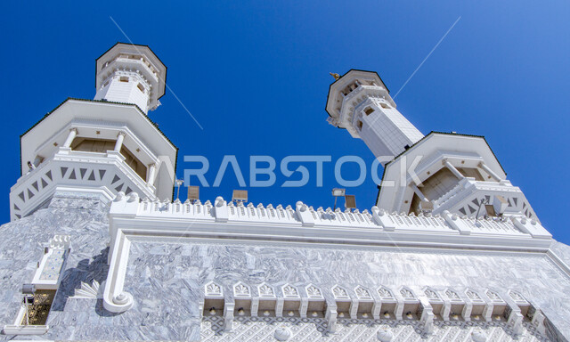 View of the clear blue sky, sacred Islamic religious landmarks, the minaret of the Holy Mosque in Mecca, a close-up of the minaret of the Grand Mosque in the Holy City of Mecca, modern architectural art in the Kingdom of Saudi Arabia, worship and getting closer to God