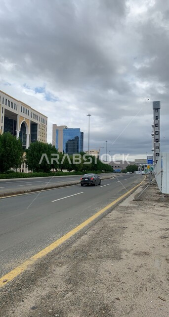 حركة المرور في الطرقات الاسفلتية المعبدة في وقت النهار، منظر الغيوم الملبدة في السماء الزرقاء، الاهتمام في زراعه الاشجار و النباتات الخضراء على حافتي الشارع، الفنادق والمنتجعات الفخمة في مكة المكرمة في المملكة العربية السعودية