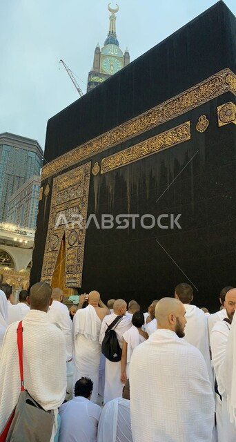 تعزيز الروحانية والاستقرار النفسي، الابراج وناطحات السحاب في الاماكن المقدسة في السعودية، الوحدة والتلاحم بين المسلمين، عكس الثقافة والتاريخ الاسلامي، العبادة و التقرب الى الله، صورة مقربة من الخلف لحجاج بيت الله الحرام يطوفون حول الكعبة المشرفة