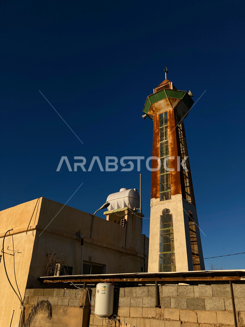 الطراز التاريخي التراثي القديم لبناء الجوامع في السعودية, الفن الهندسي المعماري لمئذنة مسجد في القصيعة بريدة القصيم, معالم دينية اسلامية مشهورة، منظر السماء الزرقاء الصافية في وقت النهار