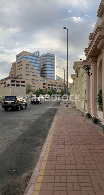 حركة السيارات في الطرقات والشوارع المعبدة,  الفنون والتصاميم الهندسية المعمارية المميزة للأبراج وناطحات السحاب، بناء الاهله مول في حي الرصيفة في مدينة مكة المكرمة قي وقت النهار، منظر السماء المليئة بالغيوم البيضاء، أماكن و معالم سياحية مشهورة