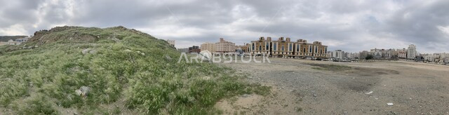 A panoramic picture of mountains and fertile meadows in the spring, rock formations and formations, green mountainous nature in the Kingdom of Saudi Arabia after heavy rains, peaks, plateaus and highlands in Mecca, cloudy sky background