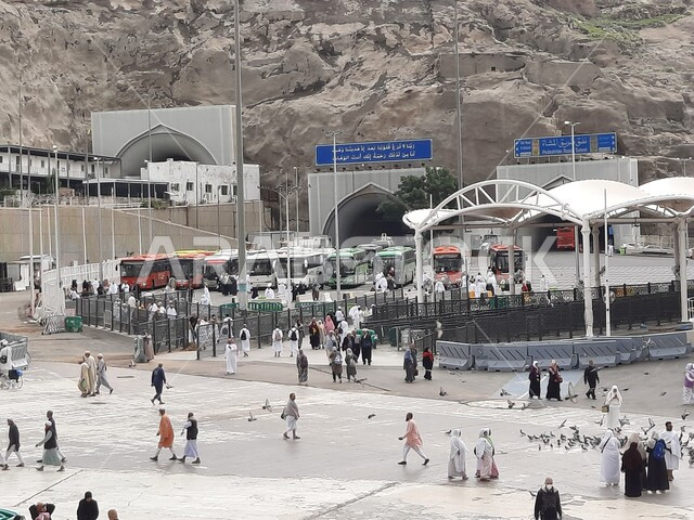 A destination for Muslims from all over the world to perform worship and get closer to God, sacred Islamic religious places and landmarks, buses transporting pilgrims and Umrah pilgrims coming to Mecca in the Kingdom of Saudi Arabia, means of access and transportation, the external entrance to the courtyard of the Sacred Mosque of God.