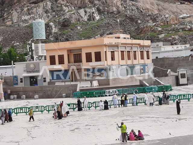 Sacred Islamic places and landmarks, promoting religious cultures, mountain peaks and heights, the library of Mecca in the Kingdom of Saudi Arabia, the outer courtyards of the Grand Mosque, performing worship and getting closer to God, the destination of Muslims from different countries, the background of the cloudy sky