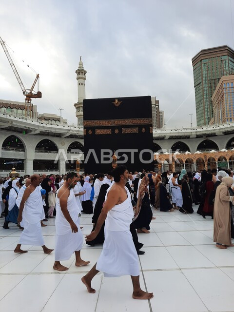 طواف حجاج بيت الله الحرام في الحرم المكي الشريف في المملكة العربية السعودية، الفن الهندسي المعماري لناطحات السحاب، معالم دينية إسلامية مقدسة في مكة المكرمة، العبادة والتقرب الى الله تعالى، منظر السماء الملبدة بالغيوم