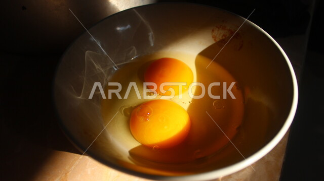 أطعمة ذات قيمة غذائبة عالية ،صورة مقربة لصفارين من البيض في وعاء أبيض، التجهيز لاعداد المأكولات الشهية ، وجبات فطور صحية و لذيذة