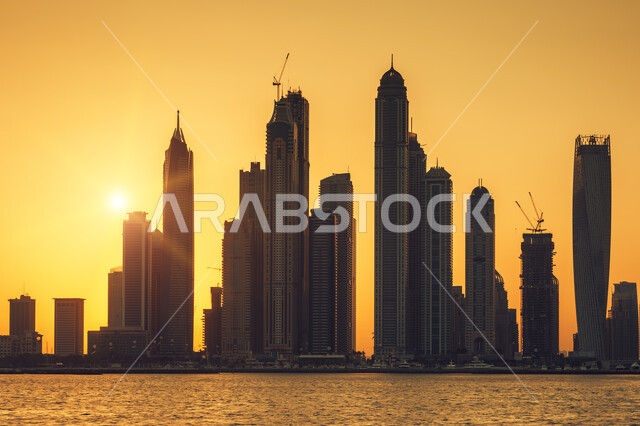 صورة بانورامية للأبراج وناطحات السحاب في مدينة دبي وقت غروب الشمس، الفن الهندسي المعماري للمباني والمنشآت في الإمارات، النمو والتطور العمراني للبنية التحتية الإماراتية، معالم دبي المشهورة، أماكن سياحية في الإمارات