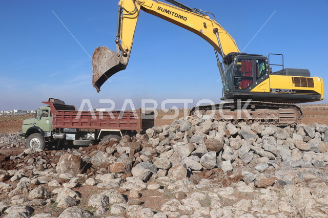 جرافة تعمل على رفع وتعبئة الرمال والحصى، مفهوم الهندسة والبناء والتطوير، مهن ووظائف هندسية في السعودية، معمل تكسير الحجارة والآلات الضخمة، قوة وتقنية عملية استخراج وتحطيم الصخور، آلات ومعدات ثقيلة