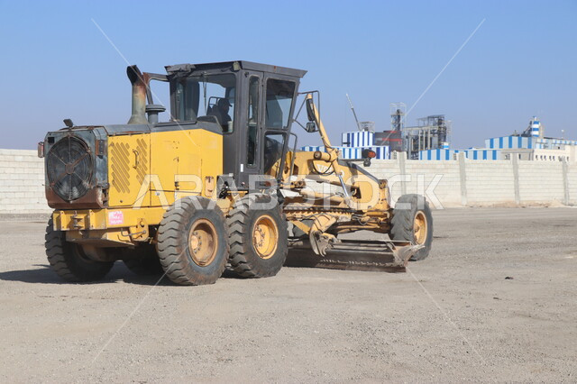 A machine for laying flat asphalt on roads, the concept of engineering, construction and development, engineering professions and jobs in Saudi Arabia, stone crushing plant and huge machines, power and technology of the process of extracting and crushing rocks, heavy machinery and equipment