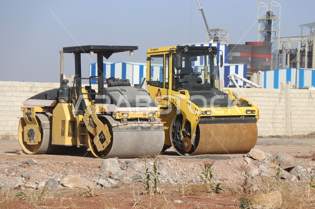 Machine for laying asphalt levelly on roads, paving main streets, concept of engineering, construction and development, engineering professions and jobs in Saudi Arabia, stone crushing plant and huge machines, power and technology of the process of extracting and crushing rocks, heavy machinery and equipment