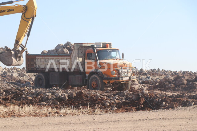 جرافة تعمل على رفع وتعبئة الرمال والحصى، مفهوم الهندسة والبناء والتطوير، مهن ووظائف هندسية في السعودية، معمل تكسير الحجارة والآلات الضخمة، قوة وتقنية عملية استخراج وتحطيم الصخور، آلات ومعدات ثقيلة