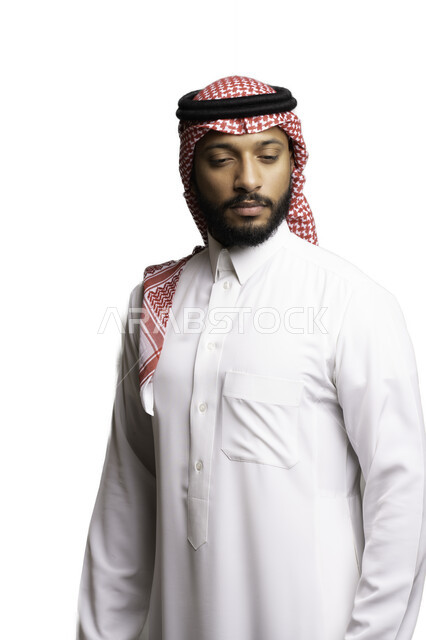 الفشل في حل المشكلات, إيماءات الحزن والإحباط, التخطيط والتفكير والتأمل، الأناقة والاهتمام بالمظهر الخارجي، بورتريه لشاب عربي خليجي سعودي يرتدي الشماغ والثوب التقليدي ينظر الى شيء ما ، خلفية بيضاء .