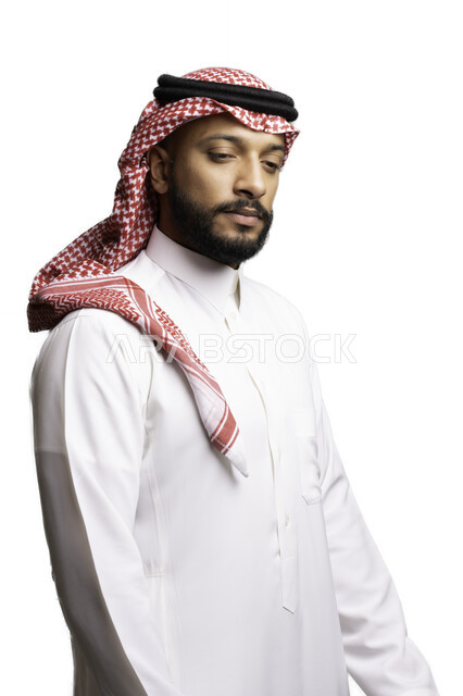 إيماءات الحزن والإحباط, الفشل في حل المشكلات, التخطيط والتفكير والتأمل، الأناقة والاهتمام بالمظهر الخارجي، بورتريه لشاب عربي خليجي سعودي يرتدي الشماغ والثوب التقليدي ينظر الى شيء ما ، خلفية بيضاء .