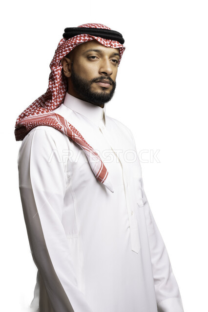 مفهوم الحزم والجدية، التأمل والتركيز لحل المشكلات, التخطيط والتفكير لاتخاذ القرارات، الأناقة والاهتمام بالمظهر الخارجي، بورتريه لشاب عربي خليجي سعودي يرتدي الشماغ والثوب التقليدي ينظر الى شيء ما ، خلفية بيضاء .