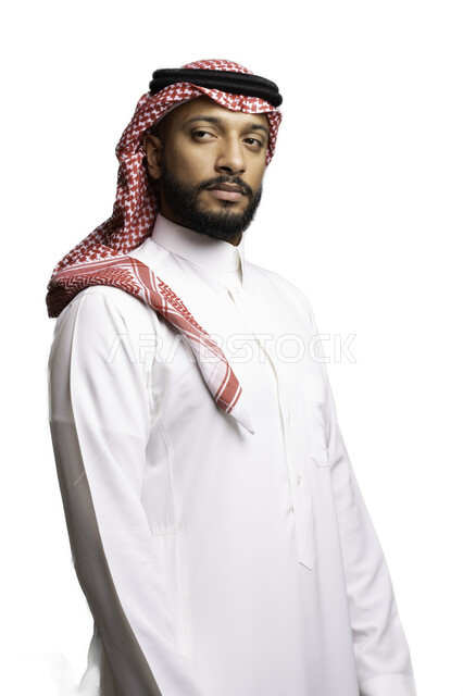 مفهوم الجدية والحزم، التأمل والتركيز لحل المشكلات, التخطيط والتفكير لاتخاذ القرارات، الأناقة والاهتمام بالمظهر الخارجي، بورتريه لشاب عربي خليجي سعودي يرتدي الشماغ والثوب التقليدي ينظر الى شيء ما ، خلفية بيضاء .
