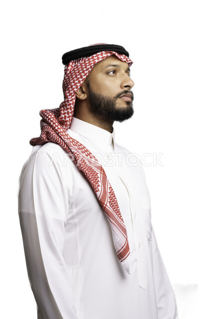 Focus and contemplation to make decisions, the concept of hesitation and confusion, planning and thinking to solve a problem, elegance and attention to external appearance, a portrait of a Saudi Gulf Arab young man wearing a shemagh and traditional dress, looking at something, white background