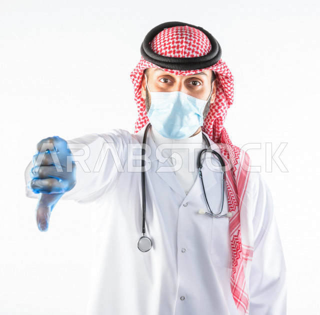 طبيبب سعودي يرتدي الكمامة ، اتباع اجراءات السلامة ، يقدم خدماته للمرضى بكل كفاءه  ، خلفية بيضاء، مفهوم الطب والرعاية الصحية