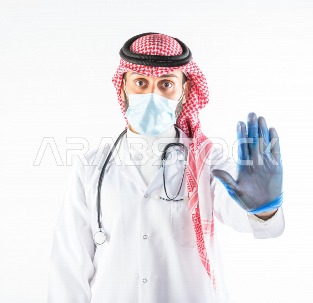 طبيبب سعودي يرتدي الكمامة ، اتباع اجراءات السلامة ، يقدم خدماته للمرضى بكل كفاءه  ، خلفية بيضاء، مفهوم الطب والرعاية الصحية