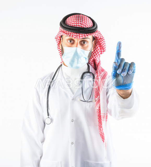 طبيبب سعودي يرتدي الكمامة ، اتباع اجراءات السلامة ، يقدم خدماته للمرضى بكل كفاءه  ، خلفية بيضاء، مفهوم الطب والرعاية الصحية