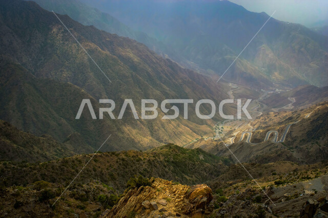 التضاريس في القمم والمرتفعات الجبلية, صورة بانورامية لجبال السودة بمنطقة عسير في المملكة العربية السعودية، معالم سياحية طبيعية مشهورة في مدينة أبها, الأجواء الضبابية الغائمة في المناطق المرتفعة, المنحدرات والطرقات الصخرية الوعرة