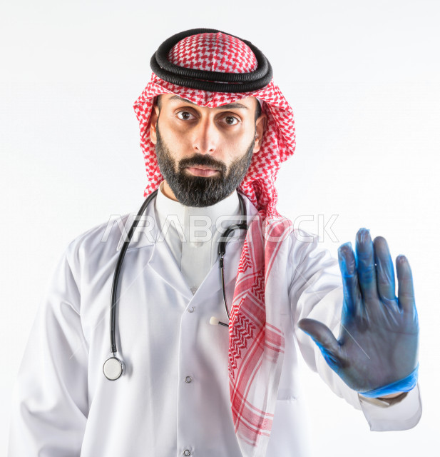 بورتريه لطبيبب سعودي خليجي مبتسم و ينظر للكاميرا ، يقدم خدماته للمرضى بكل كفاءه  ، خلفية بيضاء، مفهوم الطب والرعاية الصحية