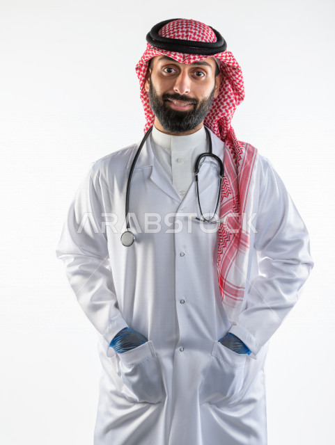 بورتريه لطبيبب سعودي خليجي مبتسم و ينظر للكاميرا ، يقدم خدماته للمرضى بكل كفاءه  ، خلفية بيضاء، مفهوم الطب والرعاية الصحية